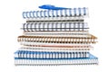 Stack of spiral notebooks with coil binding with a blue pen