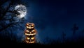 A stack of 3 spooky halloween pumpkin, Jack O Lantern, with an evil face and eyes on the grass. Royalty Free Stock Photo