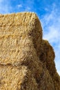 A stack of square hay bales against a blue sky Royalty Free Stock Photo