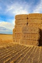 A stack of square hay bales against a blue sky Royalty Free Stock Photo