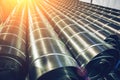 Stack of steel or metal pipes or round tubes as industrial background with perspective and sunshine effect Royalty Free Stock Photo