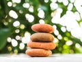 Stack Stone on Blur Plant Growth Tree wit Bokeh Background Texture Circle Pebbles Pyramid on Wood Nature,Concept for Health spa