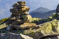 Stack of stones covered with moss on top of a mountain on mountains background. Concept of balance and harmony. Stack of zen rocks Royalty Free Stock Photo