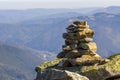 Stack of stones covered with moss on top of a mountain on mountains background. Concept of balance and harmony. Stack of zen rocks Royalty Free Stock Photo