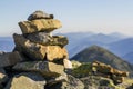 Stack of stones covered with moss on top of a mountain on mountains background. Concept of balance and harmony. Stack of zen rocks Royalty Free Stock Photo