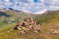 Stack of stones rocks trail marker cairn in the mountains. Against the backdrop of snowy mountains high in the mountains. Royalty Free Stock Photo