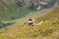 Stack of stones rocks trail marker cairn in the mountains. Against the backdrop of snowy mountains high in the mountains. Royalty Free Stock Photo