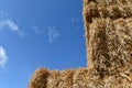 Stack of straw, square bundles straightened on each other. Blue sky. Royalty Free Stock Photo