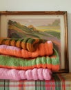 A stack of striped knit sweaters displayed on an interior shelf next to a work of art Royalty Free Stock Photo