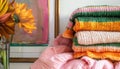 A stack of striped knit sweaters displayed on an interior shelf next to a work of art Royalty Free Stock Photo
