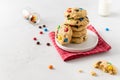 Stack of sweet cookies with colorful candies for children on white background. Side view, copy space. Bakery, confectionery. Royalty Free Stock Photo