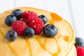 Stack of Sweet Pancakes with Fresh Blueberry, Raspberry, Apple and Maple Syrup on White Light Background