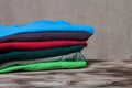 Stack of T-shirts on wooden table opposite a defocused burlap ba Royalty Free Stock Photo