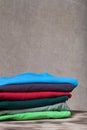 Stack of T-shirts on wooden table opposite a defocused burlap ba Royalty Free Stock Photo