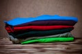 Stack of T-shirts on wooden table opposite a defocused burlap ba Royalty Free Stock Photo