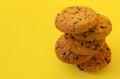 Stack of tasty chocolate chip cookies on yelllow background