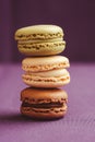 Stack of tasty macarons including vanilla, chocolate and matcha tea flavours. Royalty Free Stock Photo