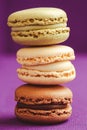 Stack of tasty macarons including vanilla, chocolate and matcha tea flavours. Royalty Free Stock Photo