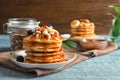 Stack of tasty pancakes with berries, nuts and syrup