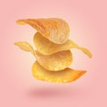 Stack of tasty potato chips falling on pink background Royalty Free Stock Photo