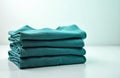 Stack of teal t-shirts folded neatly. Minimalist design on white background. Simple apparel style concept with copy space for Royalty Free Stock Photo