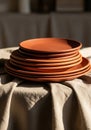 A stack of terracotta plates sitting on a beige fabric-draped table. The plates have an Royalty Free Stock Photo