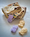 A stack of terry towels and colored soap in the form of cubs in yellow and purple