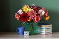 Stack of textbooks, a bouquet of dahlias and an alarm clock Royalty Free Stock Photo