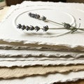 A stack of textured, handmade paper with deckled edges is arranged on a surface. O Royalty Free Stock Photo