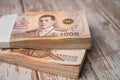 Stack of Thai baht banknotes on wooden background, business saving finance investment. Royalty Free Stock Photo