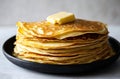 Stack of thin crepes with melting butter on top in a black plate Royalty Free Stock Photo