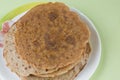 Stack of thin pancakes with crispy crust on the plate.