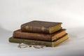 Stack of Three Antique books with a pair of vintage eyeglasses