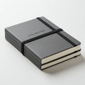 Stack of three black Moleskine notebooks, secured with a black elastic band. The Royalty Free Stock Photo