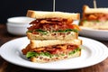 a stack of three blt sandwiches on a rectangular plate