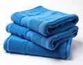 Stack of three blue terry cloth towels on white background. Soft absorbent bath linen folded neatly for storage. Clean textile Royalty Free Stock Photo