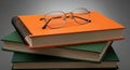 Stack of Books with Eyeglasses on Top Against a Neutral Gray Background pile reading Royalty Free Stock Photo