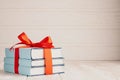 A stack of three books tied with a red ribbon with a bow and copy space: the concept of a good book - a good gift Royalty Free Stock Photo