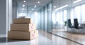 Stack of three cardboard boxes with caution labels and documents on top in modern environment with glass walls and blurred Royalty Free Stock Photo
