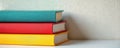 Stack of three colorful books sits on white surface. Blue, red, yellow covers represent pile of learning material. Concept of Royalty Free Stock Photo