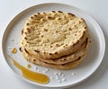 Stacked flatbreads with honey drizzle and salt flakes on a white plate food photography Royalty Free Stock Photo