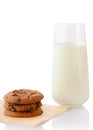 Stack of three homemade chocolate chip cookies on baking paper and glass of milk Royalty Free Stock Photo