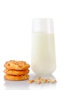 Stack of three homemade peanut butter cookies, peanuts, ear of oats and glass of milk