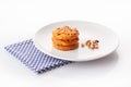 Stack of three homemade peanut butter cookies and peanuts on white ceramic plate on blue napkin Royalty Free Stock Photo