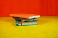 stack of three notebooks of different colors placed on a bright yellow surface Royalty Free Stock Photo