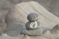 Stack of three stripy pebbles on a driftwood log Royalty Free Stock Photo