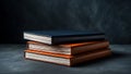 Stack of three vintage leather bound books resting on a dark textured surface Royalty Free Stock Photo