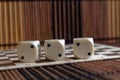 Stack of three white plastic dices on brown wooden board background. Six sides cube with black dots. Number 2 Royalty Free Stock Photo