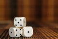 Stack of three white plastic dices on brown wooden board background. Six sides cube with black dots. Number 4, 5, 1 Royalty Free Stock Photo