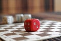 Stack of three white plastic dices and one red dice on brown wooden board background. Six sides cube with black dots. Number 4, 2 Royalty Free Stock Photo